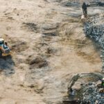 Three yellow excavators near front end loader